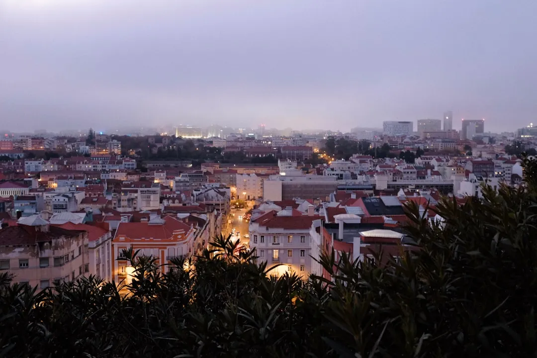 Cityscape of Lisbon at twilight with illuminated streets and buildings